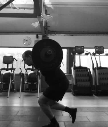 Athlete squatting with a heavily loaded barbell