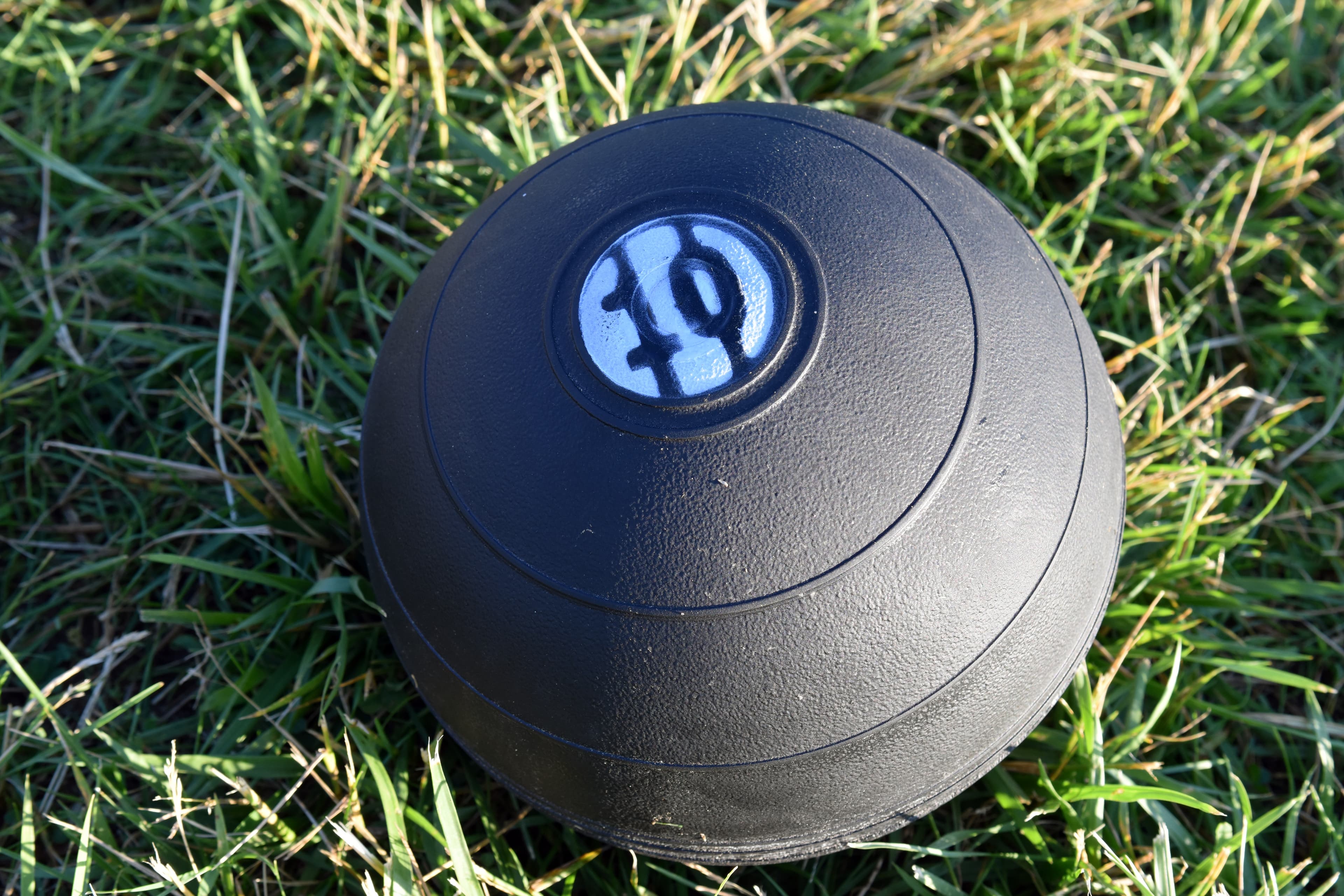 Ten-pound medicine ball resting upright on turf